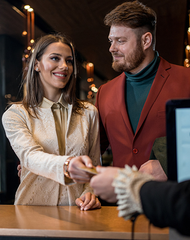 happy couple checking into a hotel during the cyber room sale